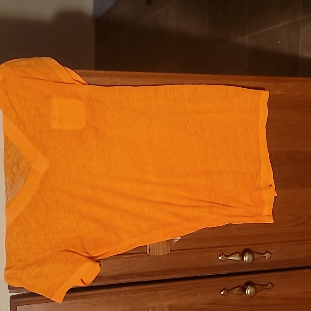 A neon orange short sleeve t shirt. It has a little pocket on the left size.